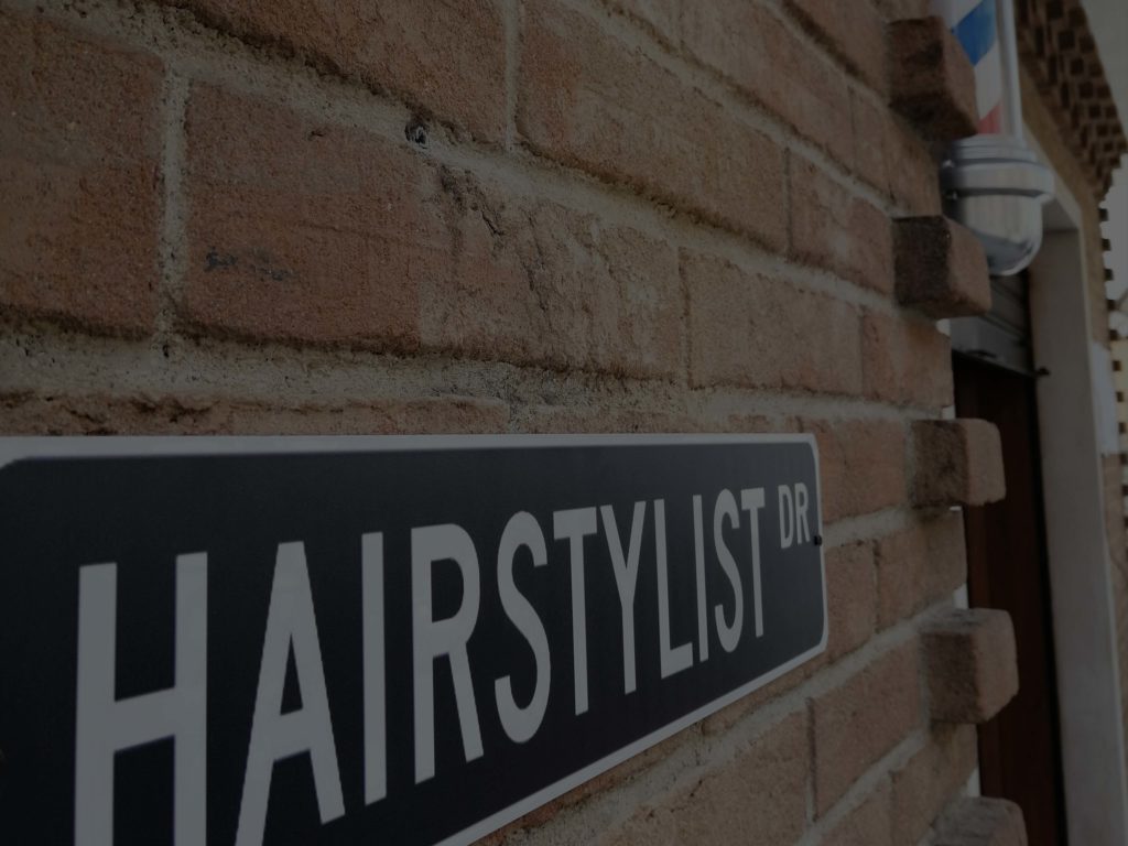 L'insegna Hairstylist all'ingresso del salone