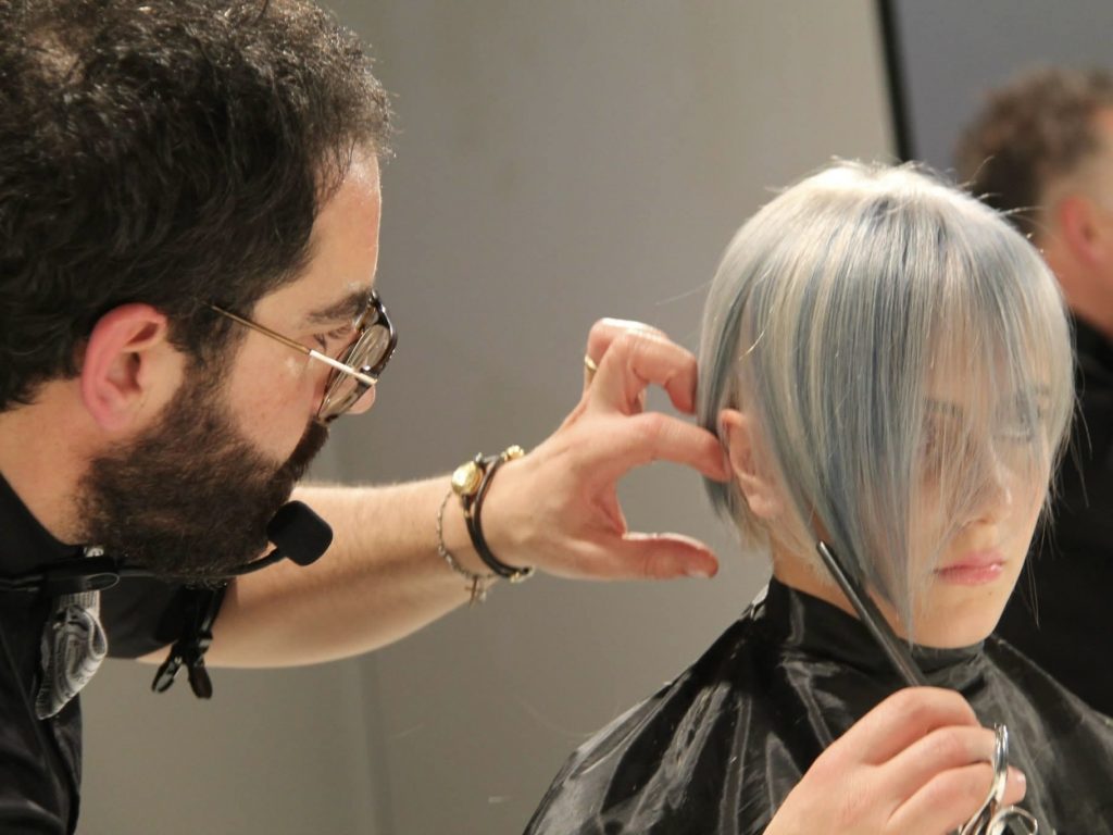 Tony Musto mentre taglia i capelli a una cliente